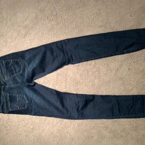 Jacob Cohen blå jeans med slim passform - Snygga blå jeans från Jacob Cohen ,kontrastsömmar och läderpatch baktill. Jeansen har smal passform. Perfekta för dig som gillar stilrena och bekväma jeans. 