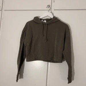 Olivgrön croppad hoodie från H&M Divided - Olivgrön croppad hoodie från H&M Divided. Luva med snörning, långa ärmar och skönt tyg. 