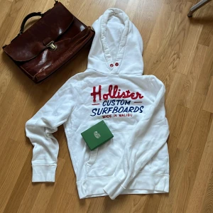 Vit Hollister Hoodie - Säljer nu en asfet vit hoodie från Hollister i mycket bra skick✌️Var inte rädd för att ställa fler frågor❤️Står storlek L passar M