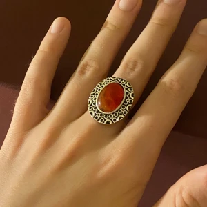 Röd orange sten silverring - Jättefin justerbar ring med röd/orange glänsande sten och fina silverdetaljer. I fint skick. Köpt second hand.