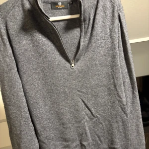 Grå stickad tröja med half zip S - Mysig grå stickad tröja från Carry Our Passion i storlek S. Tröjan har en stilren design med lång ärm och en praktisk half zip-dragkedja vid halsen. Perfekt för lager-på-lager och passar till många olika outfits. Använd typ 2 gånger då den inte passar mig