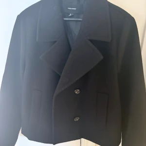 Svart kappa Vero Moda - Säljer nu min kappa jag köpt från Veronica för ungefär 600-700kr använd fåtal gånger vid säsong❣️sitter bra på mig som S-M men passar även L