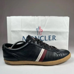 Moncler svarta sneakers - Tjena säljer ett par svarta Moncler skor, i storlek 44, dem är använda men är i väldigt bra skick, har du någon fundering är de bara till att skicka, priset går att diskutera! Självklart äkta👌