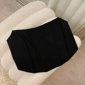 Svart topp med tight passform - Snygg svart topp med stilren och minimalistisk design. Kjolen har en tight passform och är perfekt för dig som gillar en enkel men trendig look. Materialet känns mjukt och följsamt mot kroppen. Passar till många olika outfits och är lätt att matcha.