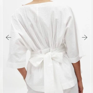 Vit blus med bred midjeband och rosett - Säljer en vit blus med bred midjeband och stor rosett i ryggen. Helt slutsåld från nakd 💞prislappen kvar 