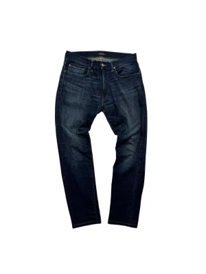 Ralph Lauren Jeans - Snygga mörkblå jeans från Polo Ralph Lauren med klassisk femficksdesign och gul kontrastsöm. Jeansen har en rak passform och är tillverkade i slitstarkt denim med läderpatch bak i midjan. Storlek: 30/32.                                               Hör av dig vid frågor eller funderingar!