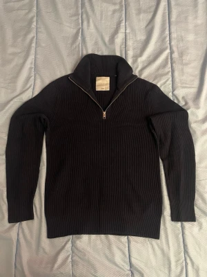 Mörkblå stickad half zip från Jack & Jones i storlek M - Hej, jag säljer en mörkblå half-zip från Jack and Jones i storlek M. Den är i bra skick och gjord i ett väldigt skönt och varmt material. Väldigt snygg ocj stilren till vintern.