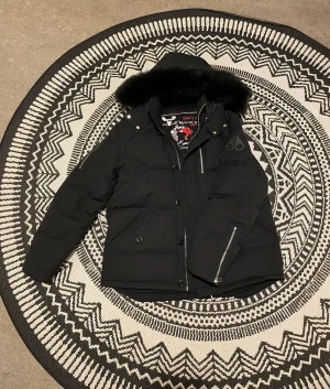Moose Knuckles 3Q  - Supervarm och skön vinterjacka. Den är fylld med dun, håller ute vind och kyla och har en mjuk pälshuva som värmer bra. Perfekt för kalla vinterdagar och funkar bra även när det är riktigt många minusgrader.