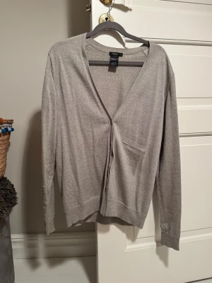 Grå merinoullkofta från Filippa K - Snygg och stilren grå kofta från Filippa K i 100% extra fin merinoull. Klassisk modell med v-ringning, knäppning framtill och en liten bröstficka. Passar till allt🩶🩶