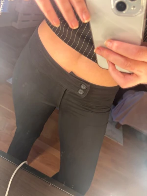 Svarta kostymbyxor med dubbelknapp - svarta kostymbyxor med två knappar i midjan. Materialet känns mjukt och stretchigt. Använt några gånger bara!