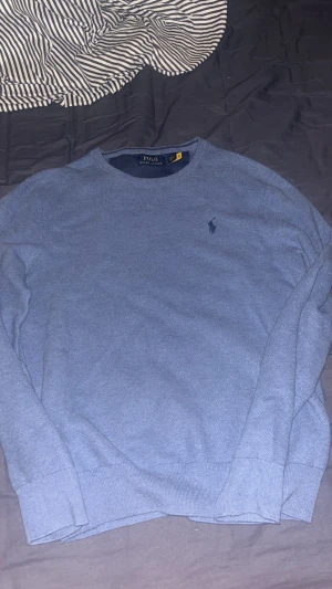 Blå stickad tröja från Polo Ralph Lauren - Säljer en riktigt snygg och skön finstickad tröja från Polo Ralph Lauren. Tröjan är endast använd 1 gång och är helt som ny, inga märken eller fläckar. Strl S, nypris 2595, mitt pris 700!