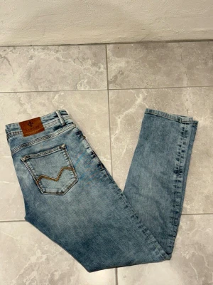 Ljusblåa jeans från Morris - Ljusblåa jeans från morris med en läderpatch på Morris logga bak. Modellen är Steve Summer, perfekta för dig som gillar att klä upp dig några snygga jeans! Storleken är i W32 L33