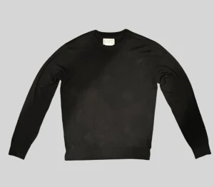 Stickad tröja  - En stilren svart långärmad tröja  med rund hals och klassisk passform. Perfekt att matcha med jeans eller under en jacka. Materialet känns mjukt och bekvämt mot huden, och tröjan har en enkel design utan detaljer eller mönster.