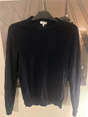 Svart merinoulltröja från Reiss - En stilren svart tröja från Reiss i mjuk merinoull. Klassisk rund halsringning och långa ärmar, perfekt för lager-på-lager eller som den är. Enkel och tidlös design som funkar till allt. Snygg ribbad kant vid ärmslut och nederkant.