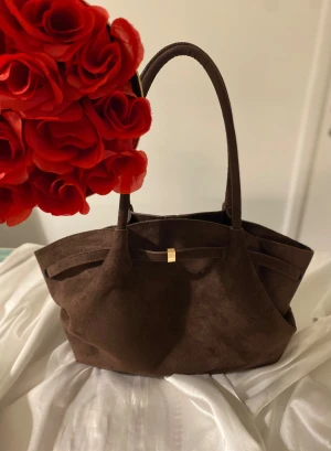 Brun mocka väska - Brun mocka väska med guld detalj✨ Säljer denna eleganta och fina bruna mocka väskan perfekt som julklapp😍 Eller till sig själv✨ Den är i ny skick med inga defekter✨ Har en guld detalj i mitten✨ Den utrymmer mycket och är stor i utrymme. Man får plats med allt man vill ha✨ Har även ett fack i väskan för till exempel korthållare✨ Stängs med guld knapp✨ Hör av dig vid frågor, rabatt finns✨🌸 #mockaväska #brunmockaväska