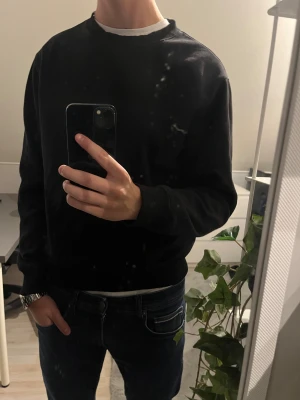 Svart Tröja från Weekday - En stilren svart sweatshirt från Weekday med rund hals och långa ärmar. Tröjan har en klassisk passform och är gjord i mjuk bomull, perfekt för chill dagar. Enkel design utan mönster eller detaljer, passar till jeans eller joggers. As skön med i super skick. Storlek M. 