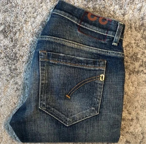 Dondup - Snygga mörkblå jeans från dondup med slitningar och tydliga kontrastsömmar. Modellen är skinny med klassiska fem fickor och låg midja. Jeansen har en cool tvättad look och är perfekta för dig som gillar en smalare passform.