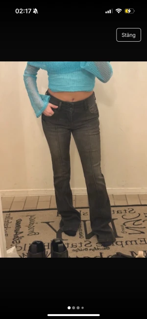 Svarta bootcut jeans från Bershka - Säljer ett par svarta bootcut jeans från Bershka i storlek 36. Jeansen har hög midja, klassiska fickor och markerade sömmar framtill. Materialet är stretchigt denim som sitter snyggt och bekvämt. Perfekta för dig som gillar en trendig siluett.