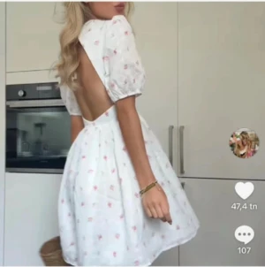 Vit blommig kortklänning med öppen rygg - Superfin vit kortklänning från H&M med puffärmar och öppen rygg med knyt. Klänningen har ett sött blommigt mönster i rosa och grönt, broderade detaljer och en lätt volang i kjolen. Perfekt för sommarens alla tillfällen!Finns en liten fläck på ryggen men ingenting som syns supermycket (se bild i slutet). 