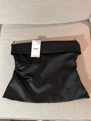 Svart satin bandeau tubtopp - svart tub topp ifrån Zara i stl M. Prislappen är inte kvar men den är endast använd en kväll. 