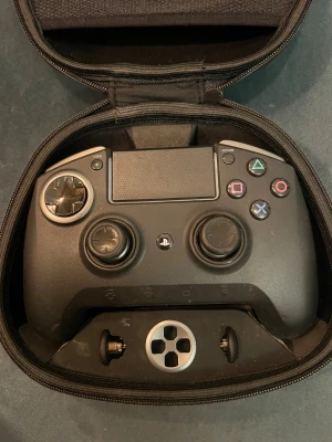 Razer Raiju Ultimate - Razer Raiju Ultimate trådlös och kabelansluten spelkontroll för PlayStation. Levereras med originalväska och utbytbara styrspakar och D-pad. Kontrollen är i gott skick med mindre tecken på användning. Perfekt för seriösa gamers som vill ha extra precision och anpassningsmöjligheter.