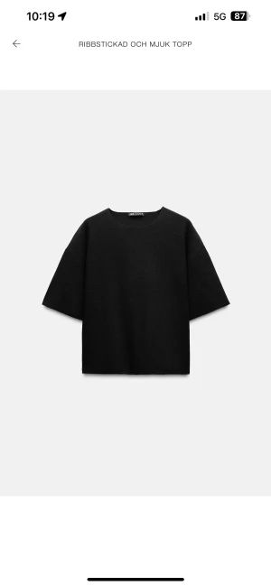 Svart ribbstickad topp från Zara - Svart ribbstickad topp från Zara med rund hals och korta ärmar. Tjockt och mjukt material som ger en skön känsla. Enkel och stilren design som funkar till många olika looks. Perfekt för dig som gillar minimalistisk stil.