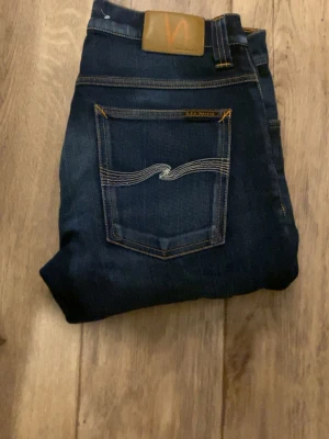 Mörkblå jeans från Nudie Jeans - Säljer ett par mörkblå jeans från Nudie Jeans i storlek W31 L32.