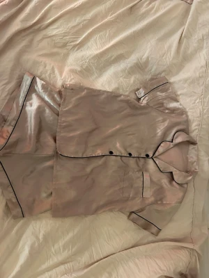 Pyjamas sett  - Ett pyjamas silkes rosa sett. En kjorta och shorts. Använt få gånger 