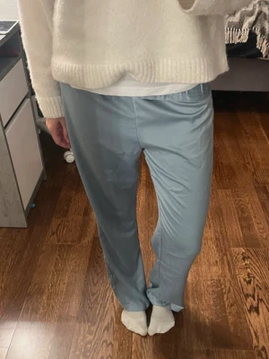 Ljusblå mjukisbyxor med resårmidja - Säljer ett par ljusblå mjukisbyxor med skön resår i midjan. Byxorna har en loose passform och raka ben, perfekta för chill dagar. Materialet känns mjukt och lätt mot huden. Enkla att matcha med en hoodie eller t-shirt.