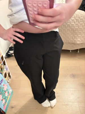 Svarta kostymbyxor från Bik Bok - Snygga svarta kostymbyxor från Bik Bok i storlek 38. Byxorna har rak passform, klassisk midja och stängs med dragkedja och hake. Materialet är mjukt och har en lätt glansig insida. Perfekta för en clean och stilren look.