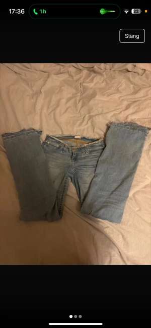 Ljusblå jeans från Nelly  - Säljer ett par ljusblå jeans från Nelly rå, fransig kant upptill. Klassisk femficksmodell med knapp och dragkedja framtill. Jeansen har en chill vibe och är gjorda i jeansmaterial. Dessa är i storlek 32 men jag brukar ha 34/36 i vanliga fall o dessa passar mig 🥰