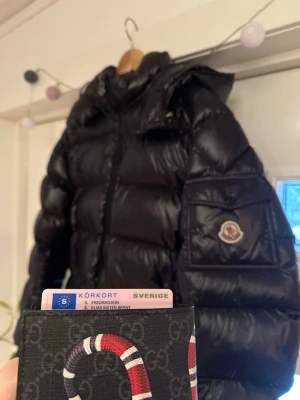 Moncler maya  - Säljer min maya för har köpt ny, storlek 6, Cond typ 7/10, små små hål på ryggen och ett större under luvan och en liten skratch på framsidan annars väldigt fin jacka, kvitto från nk finns, sätter priset på 6000kr, öppen för bud och byten!