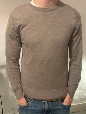 Beige tunn stickad tröja - Säljer en stilren beige stickad tröja med rund hals och långa ärmar. Tröjan har en tunn och mjuk känsla, perfekt för lager på lager. Passformen är normal och den är enkel att matcha till olika outfits.  Märke Riley, ny pris 1000kr, vårt pris 199kr, ny skick ✅. Hör av dig vid funderingar 📩