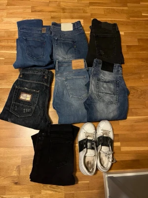 Mix av jeans och svarta byxor - Säljer ett gäng jeans. 2 par replay, 1 par dondup, 2 par jack and Jones och 2 par Adrian hammond. Jeans i väldigt bra skick som knappt är använda. Följer med ett par Valentino Opens i hyfsat skick som är väl använda. Lite varierande storlekar men -mellan 175-185 i storlekar.