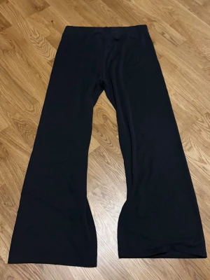 Svarta wide byxor från Love & Divine - Svarta byxor från Love & Divine i storlek L. Byxorna har en bred passform med raka, vida ben och är tillverkade i mjukt material av 80% modal och 20% polyester. 