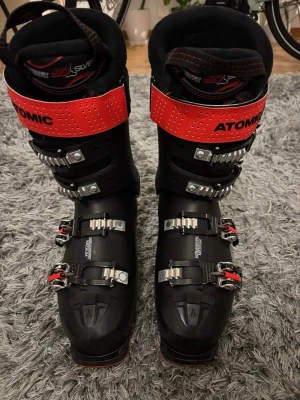 Atomic Hawx Prime 100x pjäxor - Säljer ett par svarta Atomic Hawx Prime 100x pjäxor med röda och silvriga detaljer. De är sparsamt använda i max 3 veckor sammanlagt, så det är i väldigt fint skick. Storlek 26/26,5 vilket motsvarar 41/42. 