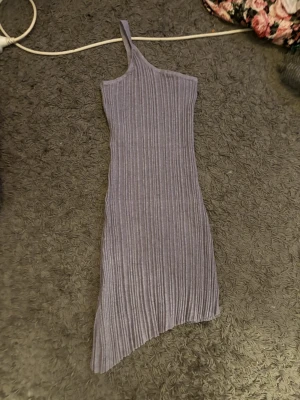 Klänning  - Jättefin klänning med axelband på ena sidan bara, skick är svårt att sätta exakt då alla har olika åsikter men enligt mig är skicket bra och jag kan inte hitta några skador när jag kollar igenom