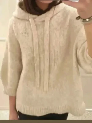 Beige stickad hoodie med huva - Mysig beige stickad hoodie med huva och breda snören framtill. Tröjan har trekvartsärm och ribbade muddar vid ärmslut och nederkant. Perfekt för kyliga dagar när du vill vara både bekväm och snygg. Från hm Storlek S!!