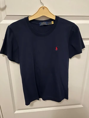 Polo Ralph Lauren T-shirt  - Tjena, säljer denna Polo Ralph Lauren T-shirt i Marinblå färg. På T-shirten står det storlek S men den passar som XS. Skriv gärna vid intresse!