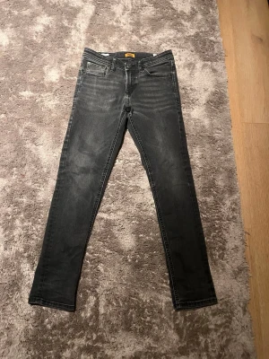 Svarta slimfit jeans - Säljer ett par svarta slim jeans med klassisk femficksdesign och smal passform. Jeansen har en snygg tvättad look och är tillverkade i stretchigt denimtyg för extra komfort. Perfekta till sneakers eller boots.