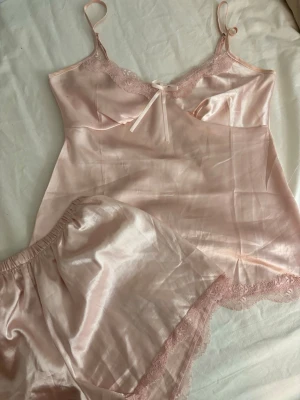 Ljusrosa pyjamassett i satin - Gulligt pyjamas sett ifrån missäy i storlek S! Både short och topp ingår! Tyvärr en liten defekt som syns på sida 2, annars i ny skick