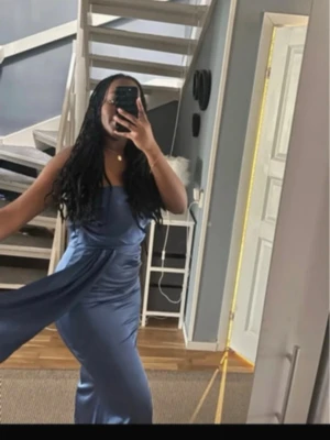 Mörkblå balklänning i satin. - Säljer en elegant mörkblå långklänning med smala axelband och draperad detalj framtill. Klänningen har en glansig satinlook och figurnära passform som ger en lyxig känsla. Perfekt för speciella tillfällen som bal eller ett bröllop😍Jag är 168.