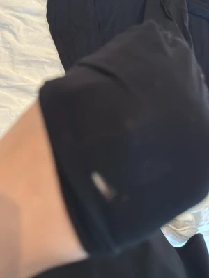 Svart långärmad topp från 157 - En enkel svart långärmad topp från 157 i storlek XS. Toppen har rund halsringning och är gjord i ett mjukt, tunt material som känns skönt mot huden. Perfekt att styla lager på lager eller bära som den är.Den har dock ett litet hår vid armen. 