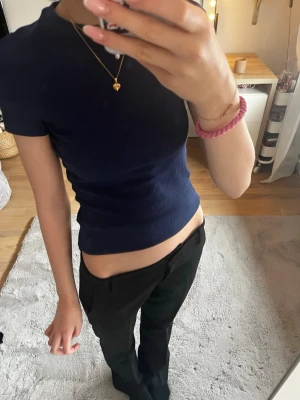 Mörkblå ribbad topp - Säljer en mörkblå ribbad topp med korta ärmar och stretchigt material💗