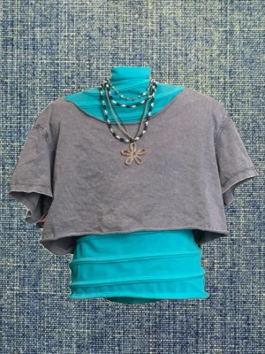 Grå croppad t-shirt - Säljer en cool croppad grå t-shirt. Den har korta ärmar och lös passform. Den är från BikBok men jag har klippt av dens neckline så lappen är inte kvar.