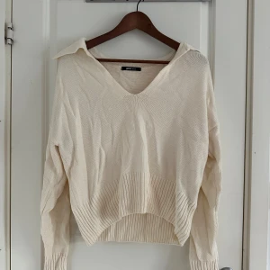Beige stickad tröja från Gina Tricot - Beige stickad tröja från Gina Tricot med v-ringning och bred krage. 🤍