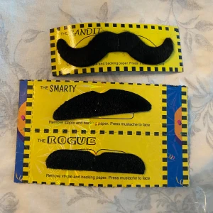 Svarta lösmustascher i olika former - Tre svarta lösmustascher i olika stilar: The Bandit, The Smarty och The Rogue. Perfekta för att skapa roliga looks eller till maskerader. Mustascherna är gjorda av syntetiskt material och fästs enkelt på huden.