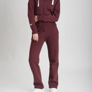 Russemerch - Mysiga vinröda mjukisbyxor i bomull med normal passform och raka ben. Perfekta för chill dagar eller när du vill vara bekväm men ändå se snygg ut. Resår i midjan och mjukt material som känns skönt mot huden.