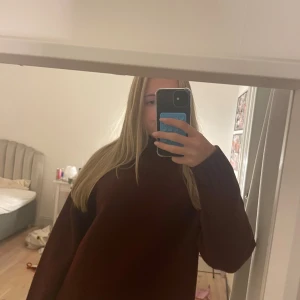 Mörkröd stickad tröja  - Säljer en mörkröd stickad polotröja med ribbad hög krage och långa ärmar. Den är perfekt för kyliga dagar och nu till hösten. Aldrig använd 