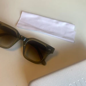 Gröna solglasögon CHIMI fyrkantig - Snygga solglasögon från CHIMI i transparent grön färg med fyrkantig form. Breda bågar och mörka glas ger en cool vibe. Perfekt accessoar för att lyfta din stil. Kommer med originalfodral (är ihoptejpad men funkar bra) och putsduk.